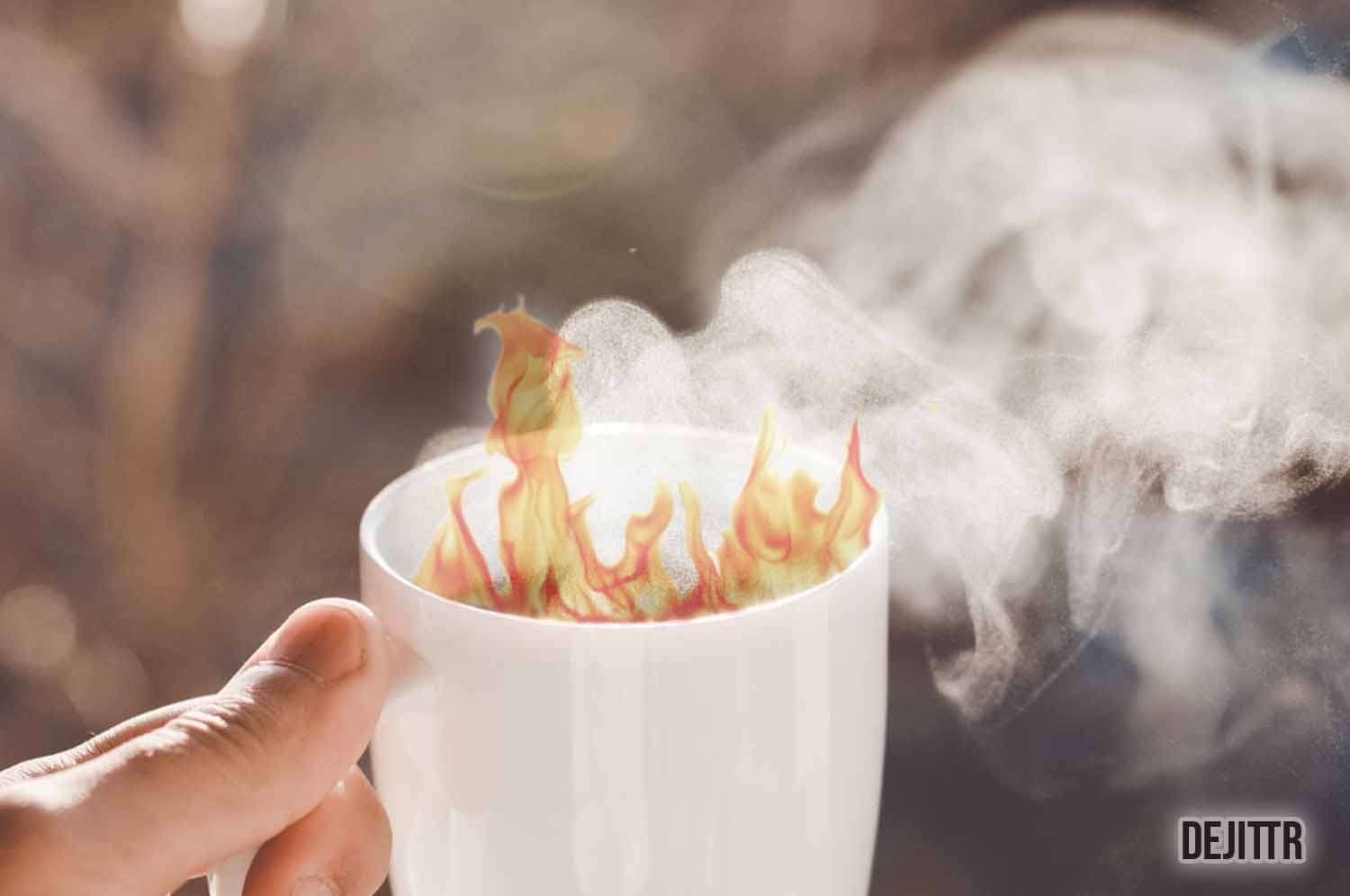 person holding a white mug with flames coming out of it