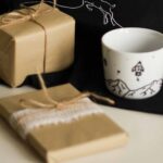 two wrapped gifts beside an empty decorative mug