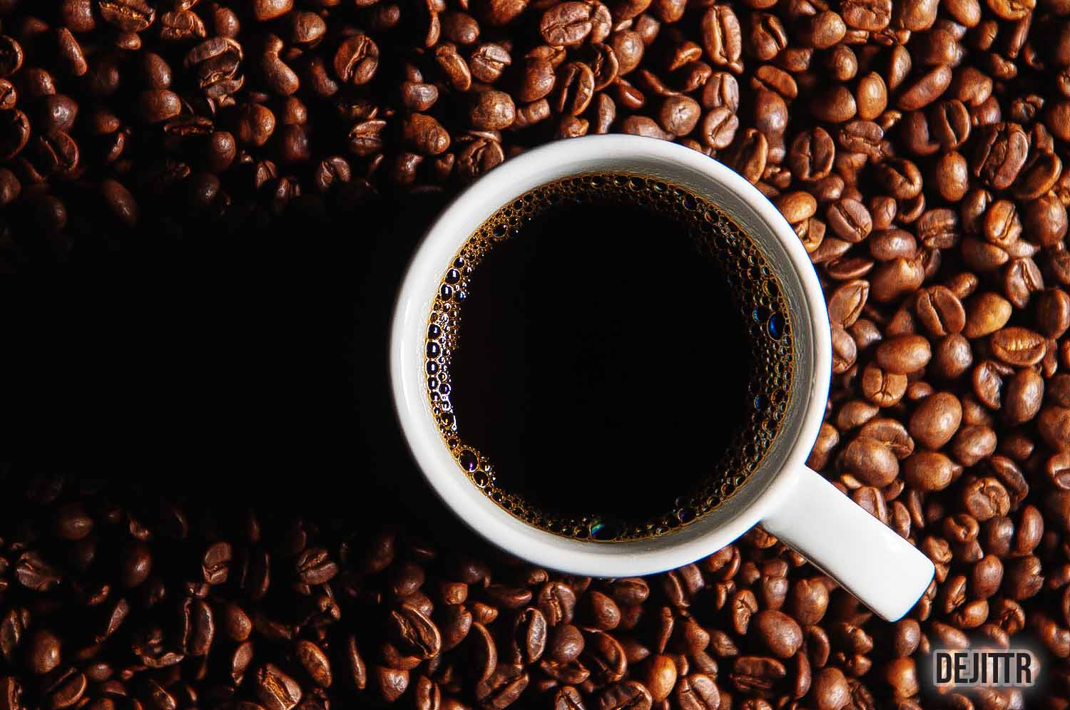 Top View Of White Cup Filled With Coffee On Top of Coffee Beans Background