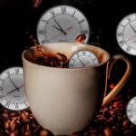 A cup of coffee surrounded by coffee beans and five clocks